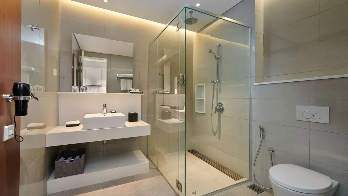 Studio Suite: Bathroom with a glass-walled rain shower, vanity and hairdryer