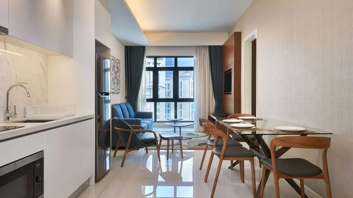 Duo Suite: Open-plan kitchen and dining table leading to the living room and city-view windows
