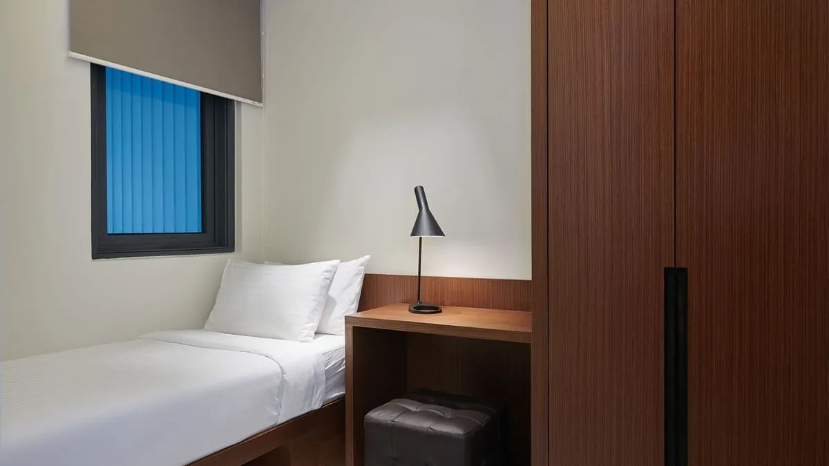 Duo Suite: Single bed with a reading lamp and writing desk