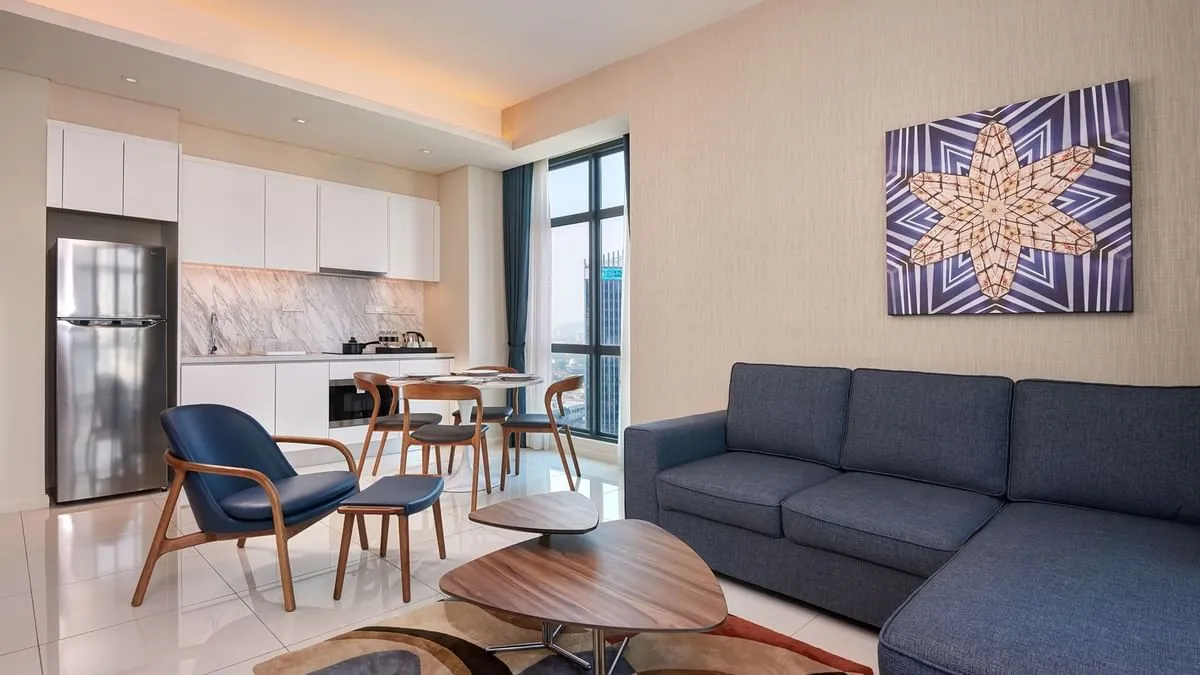 Duo Suite living area with a sectional sofa, dining table and fitted kitchen