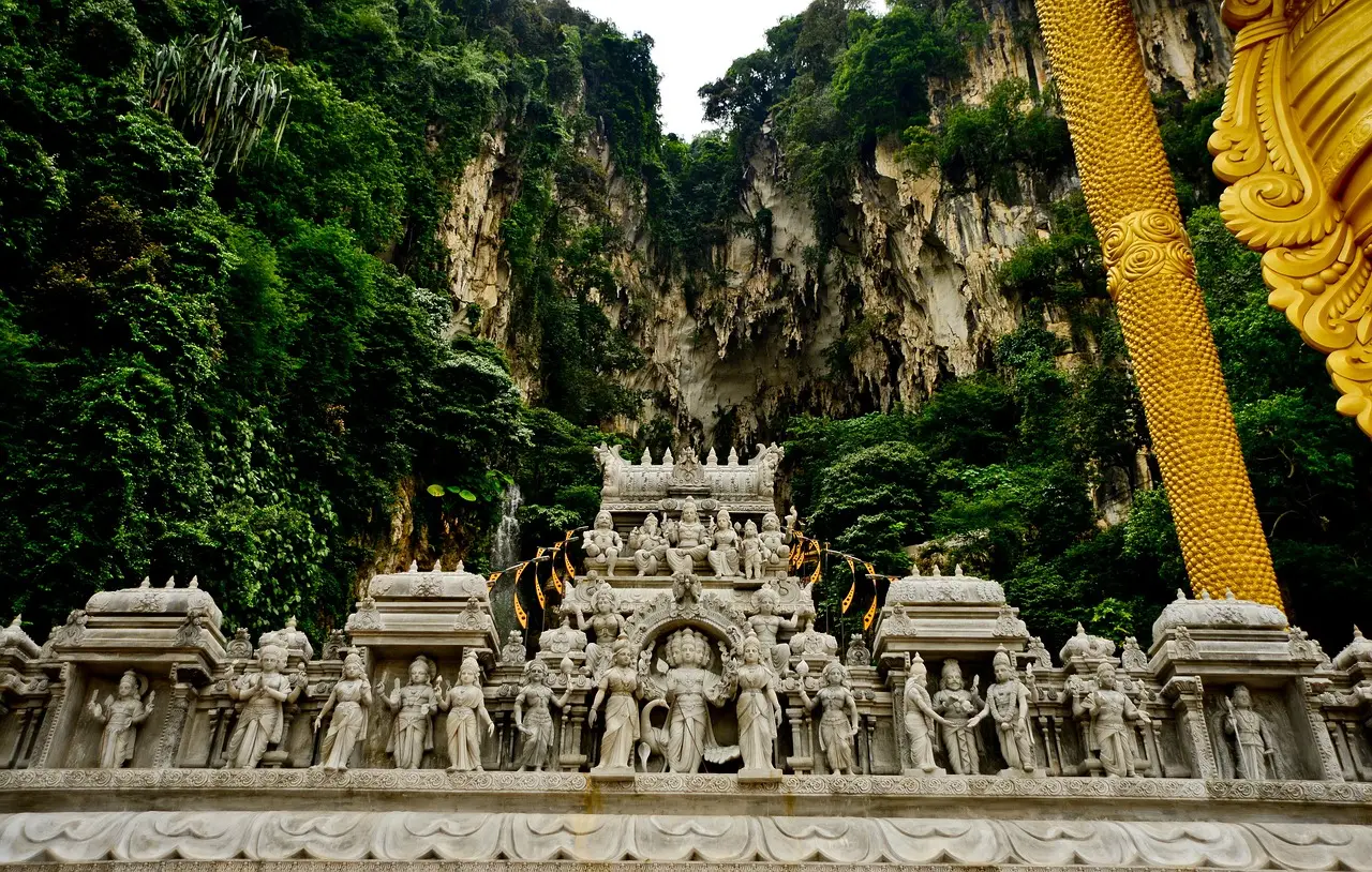 Carved temple facade beneath the limestone cliffs of Batu Caves