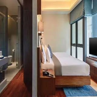 Pinnacle Suite: Bedroom with a King-sized bed and TV beside a glass-walled en-suite bathroom